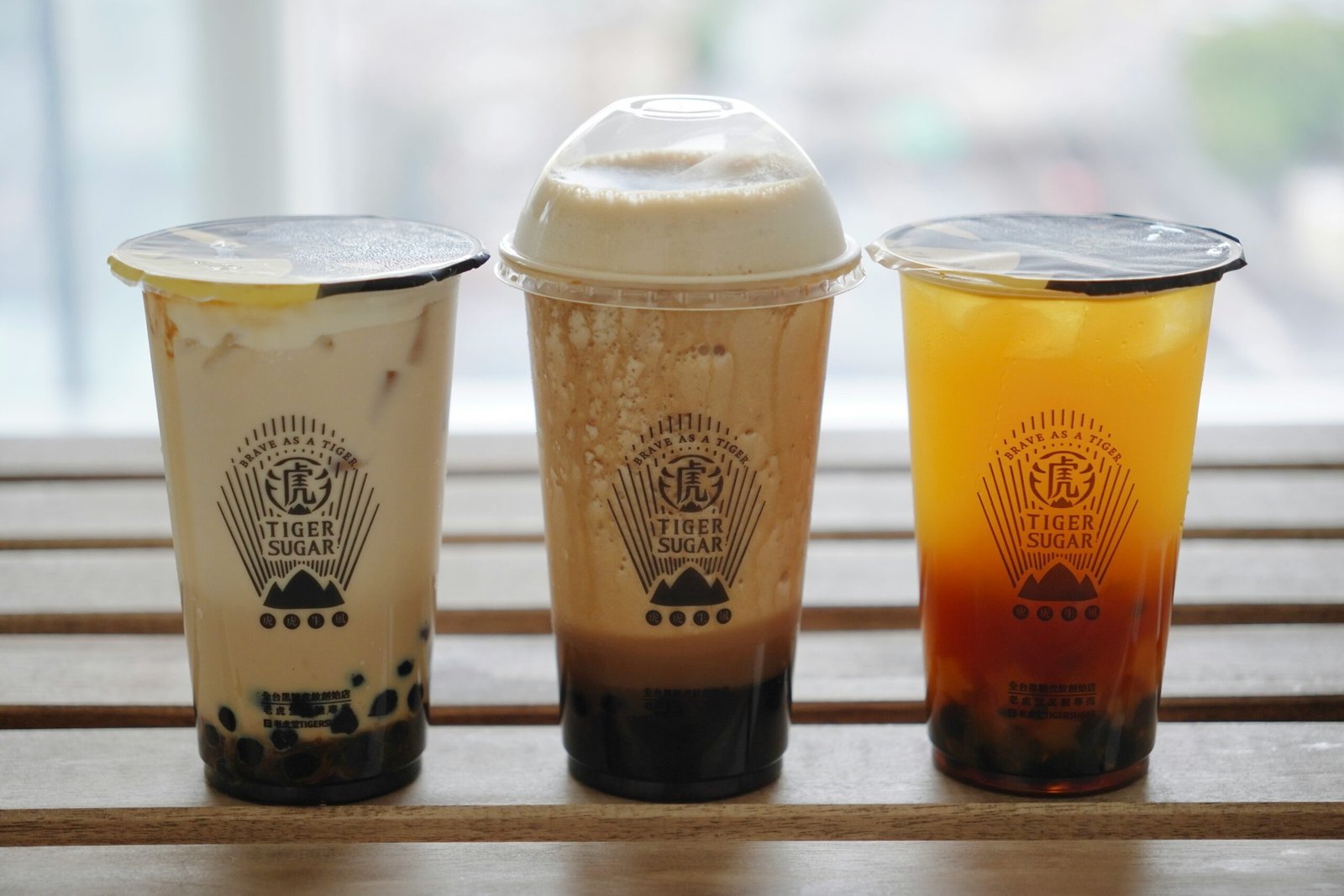 Tiger Sugar drinks — brown sugar boba milk lineup on a wooden table