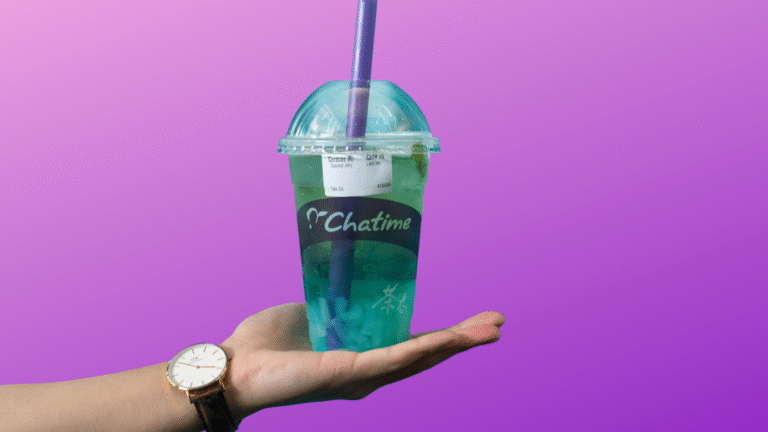 Chatime calories: Chatime cup with teal drink and purple straw held in a hand on a purple gradient background.