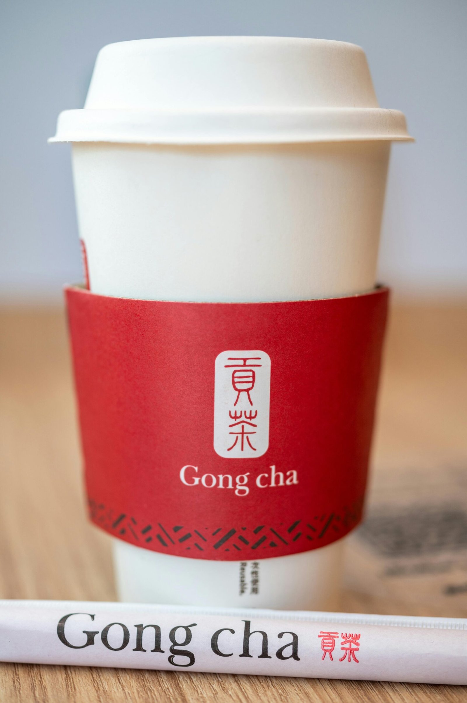 Gong Cha milk tea calories shown on a branded Gong Cha cup with red sleeve.