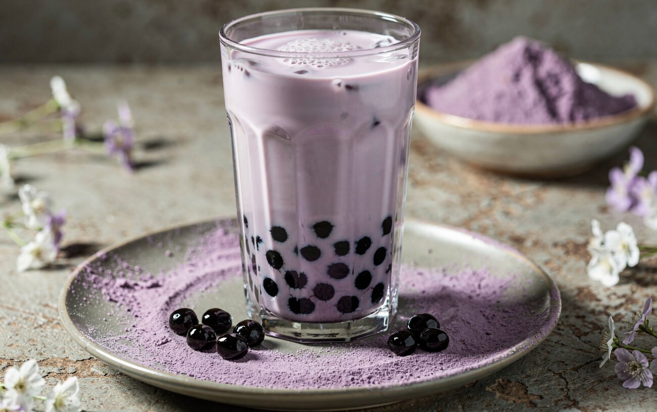 classic taro milk tea with black tapioca pearls and taro powder on a plate
